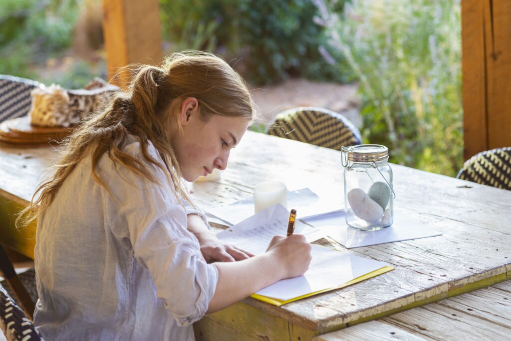 chica adolescente escribiendo en papel